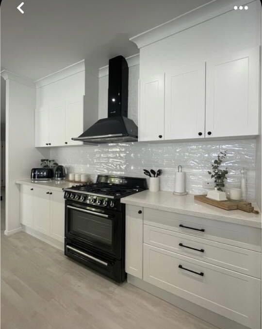 White PU kitchen with black fixtures and exposed brick for an edgy aesthetic